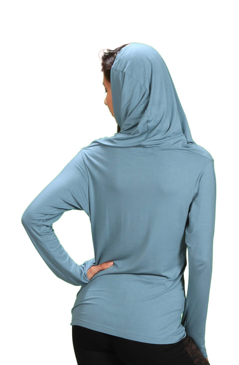 May include: A light blue hooded long-sleeve shirt with a relaxed fit. The shirt is made of a soft, comfortable fabric.
