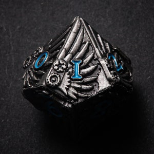 May include: A silver metal dice with blue numbers and a steampunk design. The dice has wings and gears on the sides.