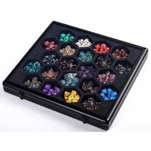 Op de afbeelding: Een zwarte koffer met een verscheidenheid aan kleurrijke polyhedrale dobbelstenen. De dobbelstenen zijn gerangschikt in afzonderlijke zeshoekige compartimenten. De dobbelstenen zijn in verschillende kleuren, waaronder groen, rood, blauw, paars en geel. De koffer heeft een zwart interieur en exterieur met twee sluitingen.