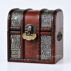 May include: A small wooden treasure chest with a brass lock and hinges. The chest is decorated with an intricate design of white and black patterns.