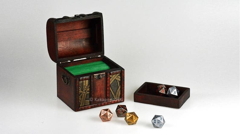May include: A wooden treasure chest with a green felt lining, open to reveal a set of metal dice. The dice are in a separate wooden tray.