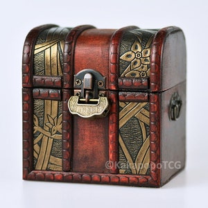 May include: A small wooden treasure chest with a hinged lid, ornate gold and black floral designs, and a brass latch.