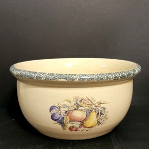 May include: A cream-colored ceramic bowl with a green rim and a painted design of fruit, including a pear, an apple, and plums.