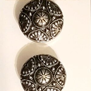 May include: Two antique silver buttons with a decorative floral design. The buttons are on a white card with the text "Streamline" and "Antique Silver".