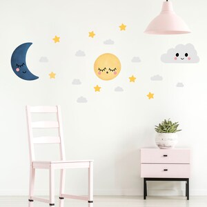 May include: A set of wall decals featuring a sleeping moon, a sleeping sun, a smiling cloud, and yellow stars. The decals are on a white wall with a pink chair and a pink nightstand.