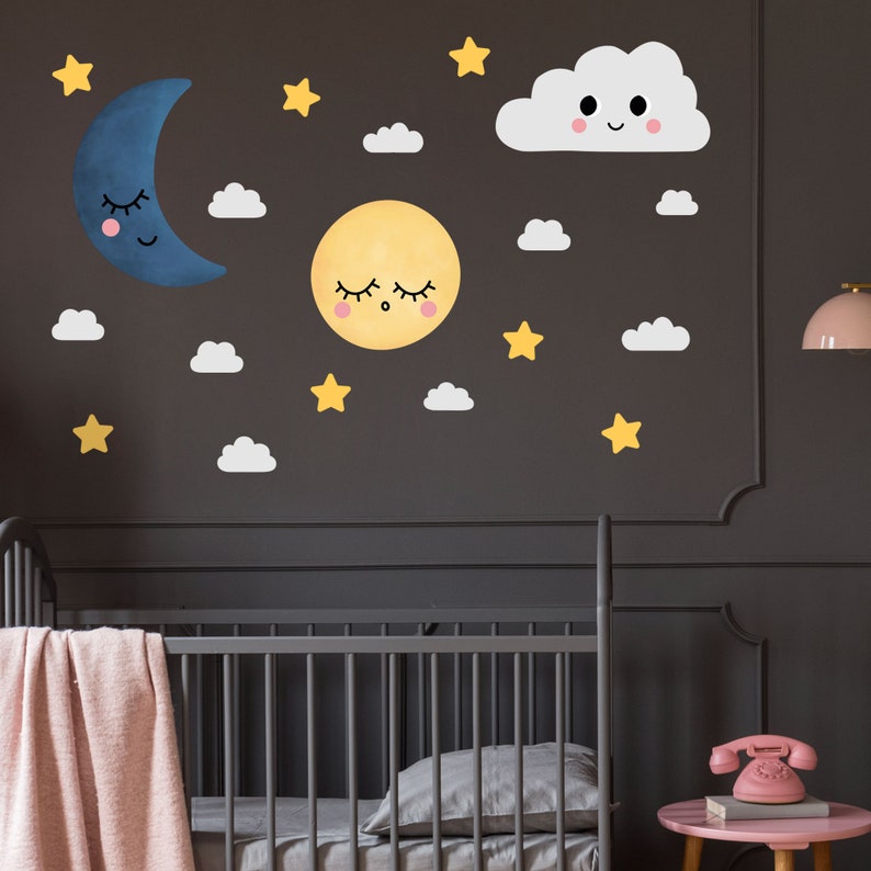 May include: A nursery wall decal set featuring a yellow sun, a blue crescent moon, a white cloud with a smiling face, and yellow stars. The decals are perfect for a baby's room or a child's bedroom.