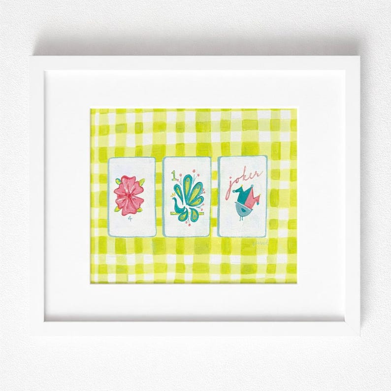 Puede incluir: Una impresi&oacute;n en acuarela enmarcada con tres naipes con ilustraciones caprichosas. Las cartas est&aacute;n sobre un fondo de cuadros amarillos y blancos. Las cartas representan una flor rosa, un dise&ntilde;o verde y azul y un p&aacute;jaro con la palabra "joker".
