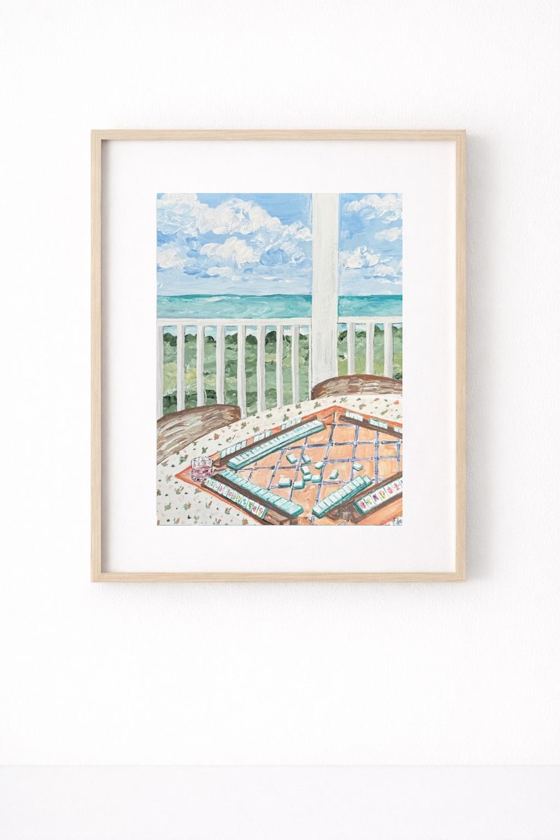 May include: Watercolor painting of a porch overlooking the ocean. A table with a floral tablecloth holds a Mahjong game in progress. The sky is blue with fluffy white clouds, and the sea is turquoise.
