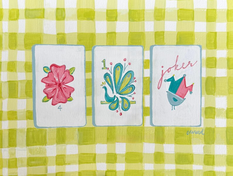 Puede incluir: Tres naipes ilustradas. La primera carta presenta una flor rosa y el n&uacute;mero 4. La segunda carta tiene un dise&ntilde;o turquesa y amarillo con el n&uacute;mero 1. La tercera carta dice "joker" y tiene un p&aacute;jaro con un gorro de buf&oacute;n.
