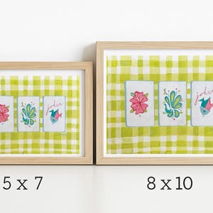 Puede incluir: Dos impresiones art&iacute;sticas enmarcadas con dise&ntilde;os de naipes. Cada carta tiene una ilustraci&oacute;n floral o de p&aacute;jaro en rosa, verde azulado y verde. El fondo es un patr&oacute;n de cuadros verdes y blancos. Las medidas son 12,7 x 17,8 cm y 20,3 x 25,4 cm.