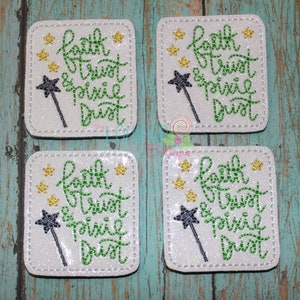 May include: Four white square coasters with green glitter and gold glitter stars. The coasters have the text "faith trust & pixie dust" in green cursive lettering with a black and white wand with a star on the end.