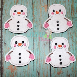 May include: Four white felt snowman appliques with pink cheeks, black eyes, and orange noses. Each snowman has black buttons and brown twig arms. The snowmen are holding pink mittens.