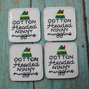 May include: Four white square patches with black stitching around the edges. Each patch features a green and yellow elf hat with a red tip and the text "COTTON Headed NINNY muggins" in black cursive writing.