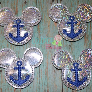 May include: Four silver holographic mouse-shaped patches with stitched edges. Each patch features a dark blue embroidered anchor in the center. The material has a reflective, glittery finish that catches the light, creating a multi-colored effect.
