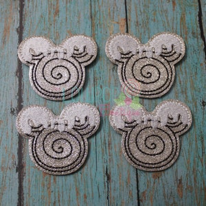 May include: Four silver glitter mouse-shaped ornaments with a black swirl design.