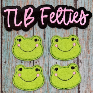 May include: Four green felt frog appliques with black eyes and pink cheeks. The frogs have a stitched smile and are perfect for adding a whimsical touch to crafts.