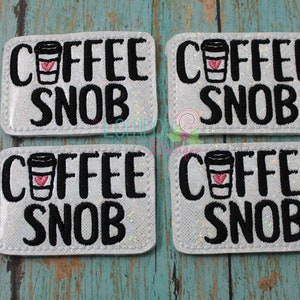 May include: Four white iron-on patches with black text that reads "Coffee Snob" and a black and white illustration of a coffee cup with a red heart.