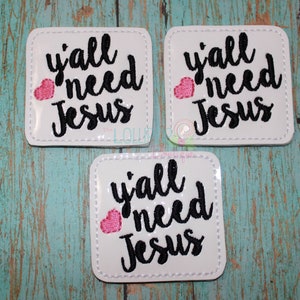 May include: Three white square patches with black embroidered text that reads "y'all need Jesus" with a pink heart in the corner of each patch.