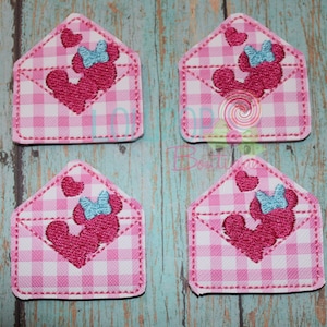 May include: Four pink and white gingham fabric patches with an embroidered design of a cartoon character with a bow and hearts. The character is pink and the bow is blue.