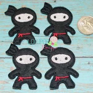 May include: Four black felt appliques of ninjas with red sashes. The ninjas are wearing white masks and have black eyes. The appliques are about the size of a US quarter.