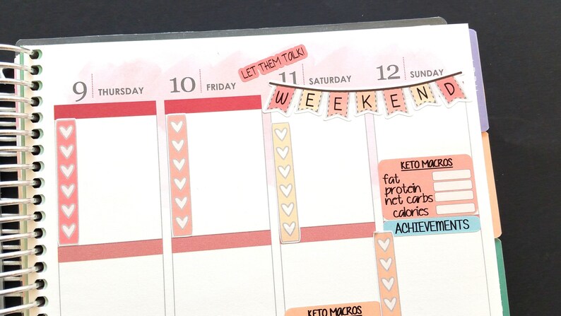 Pu&ograve; includere: Un planner settimanale con un adesivo a forma di cuore rosa e bianco su ogni giorno. Le caselle del sabato e della domenica hanno uno striscione che dice "WEEKEND". La casella della domenica ha anche un adesivo rosa e bianco che dice "KETO MACROS" con una tabella per tenere traccia di grassi, proteine, carboidrati netti e calorie. C'&egrave; anche un adesivo blu che dice "RAGGIUNGIMENTI".