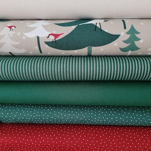 Könnte beinhalten: Ein Stapel Stoffrollen in verschiedenen Mustern und Farben. Die oberste Rolle ist einfarbig cremefarben. Darunter befindet sich eine Rolle mit einem Weihnachtsbaumdesign mit roten Vögeln. Weitere Rollen sind grüne Streifen, einfarbiges Grün, weiße Punkte und rote Punkte.