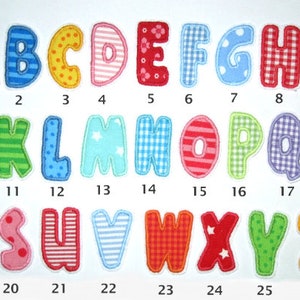 Könnte beinhalten: Ein Set aus 26 bunten Filzbuchstaben, jeder mit einem anderen Muster. Die Buchstaben sind von 1 bis 26 nummeriert.