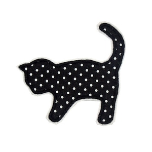 Könnte beinhalten: Schwarze Stoffkatzensilhouette mit weißen Punkten. Die Katze steht auf allen vieren mit eingerolltem Schwanz.
