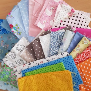 Könnte beinhalten: Eine Sammlung von Stoffmustern in verschiedenen Farben und Mustern. Designs umfassen Punkte, Sterne, Anker, Schwäne und Blumenmuster. Die Farben reichen von Blau und Rosa bis hin zu Gelb und Orange. Ideal für Quilt- oder Bastelprojekte.
