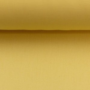 Könnte beinhalten: Nahaufnahme eines gelben Stoffes mit subtiler Textur. Der Stoff ist in der Mitte gefaltet, wodurch eine Falte entsteht.
