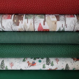 Könnte beinhalten: Ein Stapel aus sechs gefalteten Stoffballen. Die Muster umfassen Rot mit weißen Punkten, eine winterliche Dorfszene, grüne und weiße vertikale Streifen, Grün mit weißen Punkten, eine Winterlandschaft mit Pferdeschlitten und einen einfarbigen Stoff.