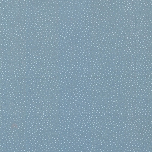 Op de afbeelding: Een stoffige blauwe stof met een dicht, herhalend patroon van kleine witte stippen die gelijkmatig over het hele oppervlak zijn verdeeld. Het textiel heeft een matte afwerking en een consistente, uniforme textuur over het zichtbare gebied.