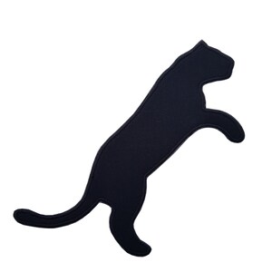 Könnte beinhalten: Schwarze Silhouette einer Katze, die mit ausgestreckten Beinen in die Luft springt. Die Katze ist nach rechts gerichtet.