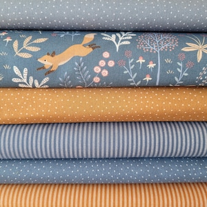 Könnte beinhalten: Ein Stapel Stoffrollen in verschiedenen Mustern und Farben. Die Stoffe umfassen Blau mit weißen Punkten, Türkis mit einem Fuchs- und Blumendesign, Senfgelb mit weißen Punkten, blau-weiße Streifen und orange-weiße Streifen.