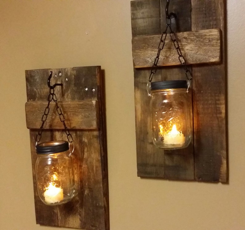 Pu&ograve; includere: Due applique da parete in legno rustico con barattoli di vetro sospesi e candele. Ogni applique &egrave; realizzata in legno riciclato e ha un gancio e una catena in metallo per tenere il barattolo.