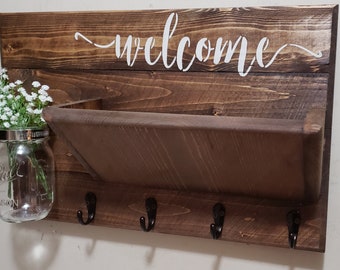 May include: A rustic wooden wall organizer with a shelf, hooks, and a sign that says "welcome".