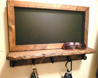 Estante rústico de madera con pizarra y ganchos para llaves, decoración de estilo granja.