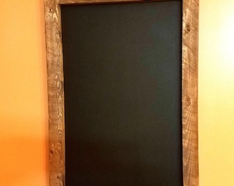 May include: A rustic wooden framed chalkboard with a rope hanger. The chalkboard is black and the frame is a dark brown wood.