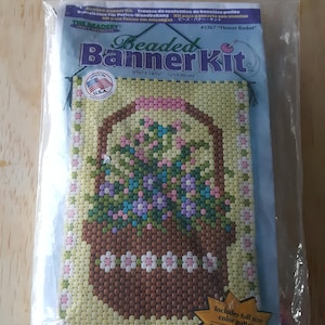May include: A beaded banner kit with a flower basket design. The kit includes a full-size color pattern and is 9 1/2" x 14 1/2" (25 x 38 cm).