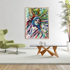 Puede incluir: Pintura abstracta de la Estatua de la Libertad en un estilo colorido con pintura roja, azul, verde, amarilla y blanca. La pintura est&aacute; enmarcada y colgada en una pared blanca.