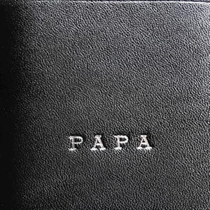May include: A black textured surface featuring the word PAPA embossed in a clean, sans-serif font. The material has a consistent, fine-grained pattern across the entire visible area, providing a matte finish with subtle highlights on the texture.