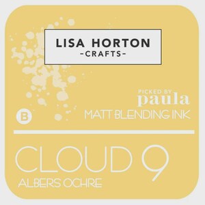 May include: A square, yellow label with rounded corners. The label features the text "LISA HORTON - CRAFTS-" in a white rectangle. Below, it reads "PICKED BY paula" and "MATT BLENDING INK." The words "CLOUD 9" and "ALBERS OCHRE" are also displayed.