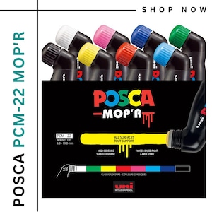 Puede incluir: Un juego de ocho rotuladores de pintura POSCA PCM-22 MOP'R con punta redonda. Los rotuladores tienen cuerpos negros y tapas de colores. El embalaje incluye el texto "POSCA - MOP'R" y "TODAS LAS SUPERFICIES".