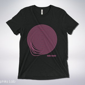 May include: Black t-shirt with a pink spiral design and the text "feeble minded" printed on the front.