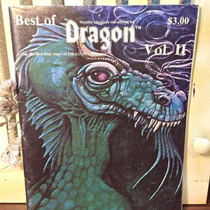 Puede incluir: La portada de la revista "Best of Dragon Vol II" presenta una ilustración detallada de la cabeza de un dragón verde. El título de la revista y el número del volumen se muestran de forma destacada, con el precio de $3.00 visible en la esquina superior derecha. La revista es de los primeros cuatro años de Dragon.