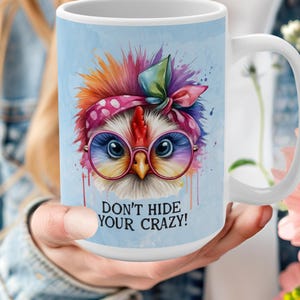 May include: White ceramic mug featuring a colourful illustration of a chicken wearing glasses and a headband. The text "Don't hide your crazy!" is printed on the mug.