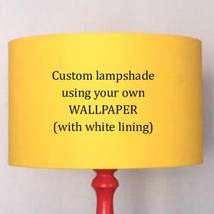 Può includere: Un paralume personalizzato con esterno giallo brillante e fodera bianca. Il testo sul paralume recita "Custom lampshade using your own WALLPAPER (with white lining)". La base della lampada è rossa.