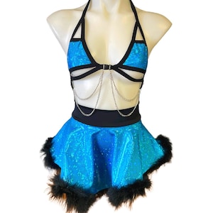 May include: A turquoise and black two-piece outfit with a halter top and a mini skirt. The top has a chain detail and the skirt has a fluffy black trim.