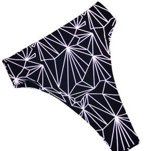 May include: Black high-waisted bikini bottom with a white geometric pattern.