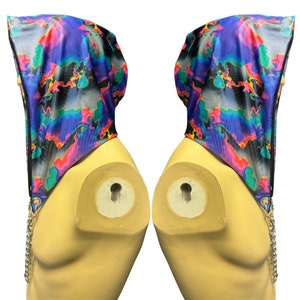 May include: A hooded garment with a colorful abstract print in shades of blue, pink, green, and yellow. The hood is lined with black fabric and has a zipper closure.
